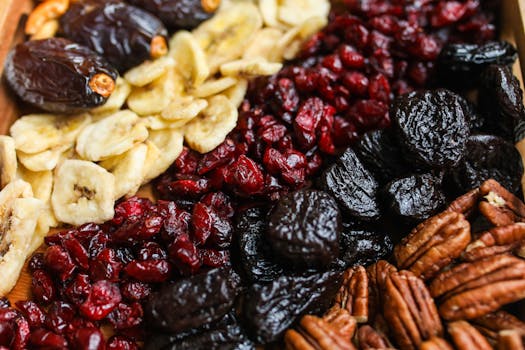 Vibrant mix of dried fruits and nuts on a wooden tray, perfect for healthy snacking.