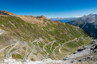 Breathtaking aerial view of the winding Stelvio Pass in the Alps on a sunny day.